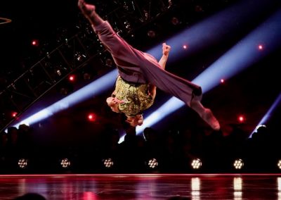 Male solo dancer flipping over mid-air, legs in split