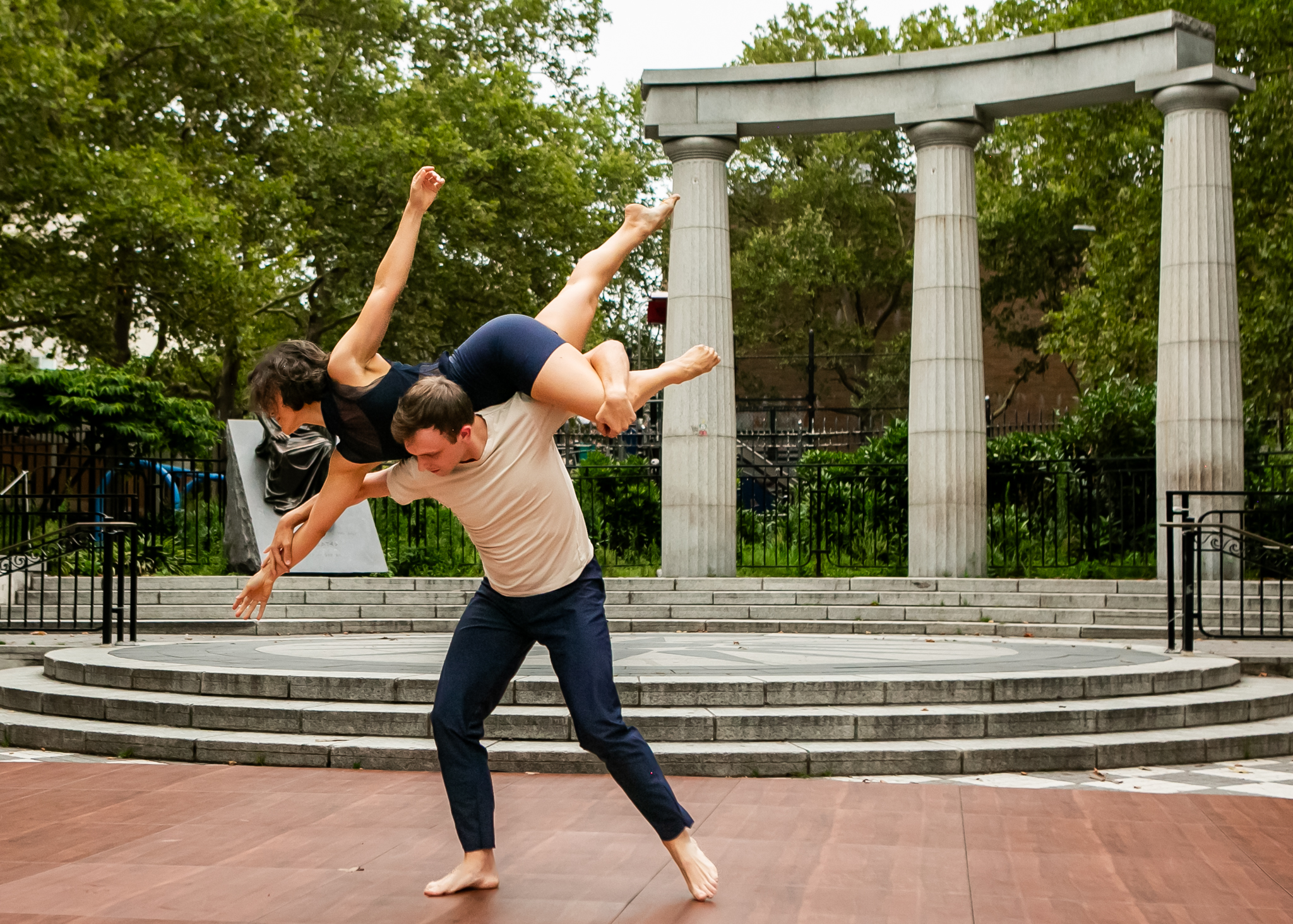 Male dancer lifting a female dancer across his shoulders as though she is flying